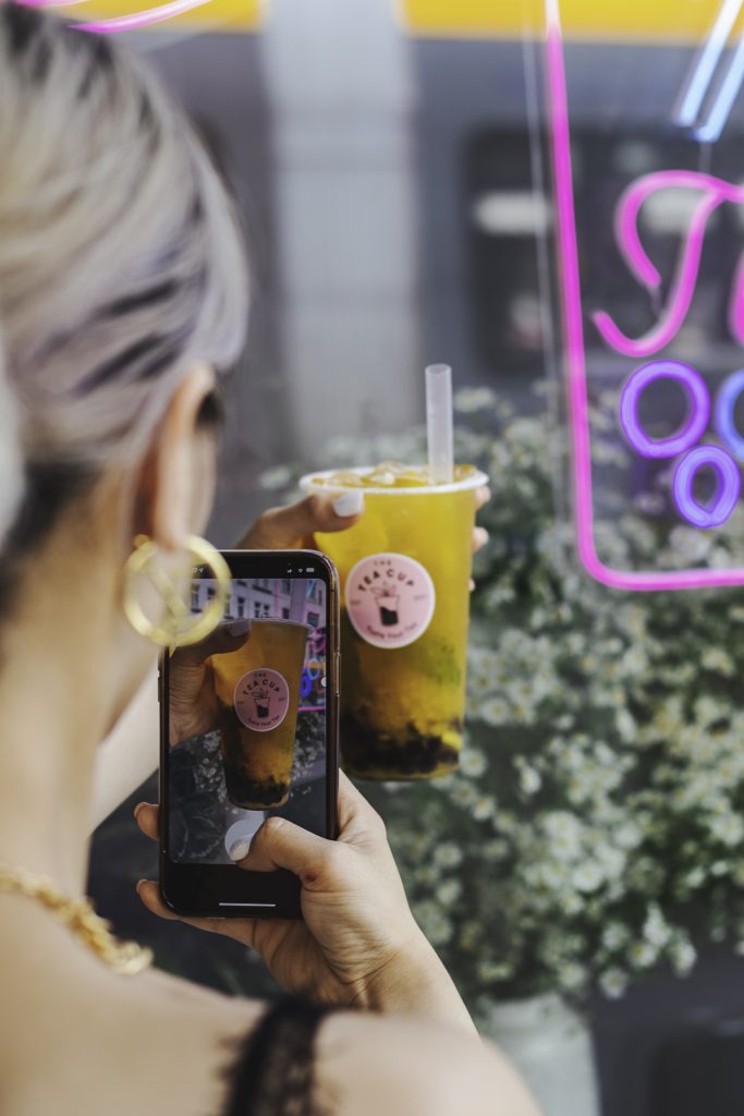 Person fotografiert ihren Mango Bubble Tea